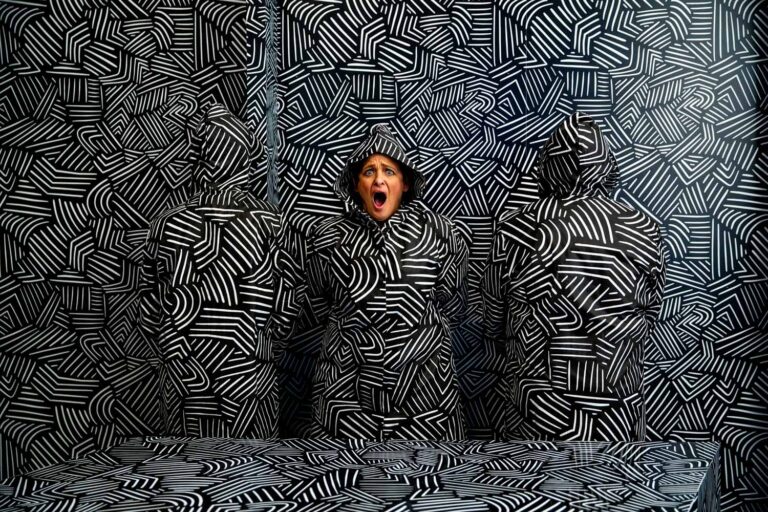 Woman in front of illusion wall at Paradox Museum.